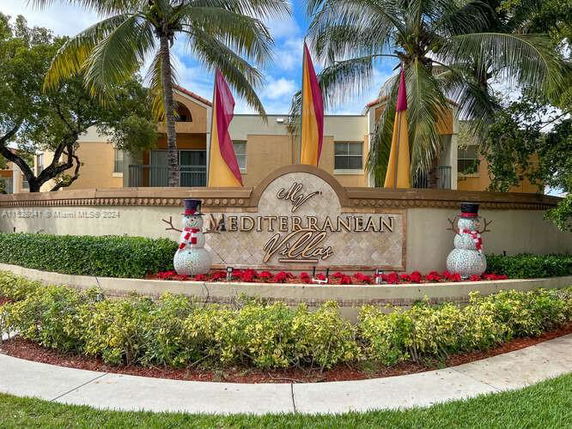 Front view of a Mediterranean-style building with decorative pillars and signage.