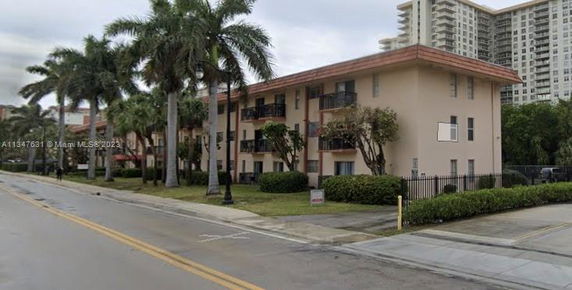 Front view of a three-story apartment building with balconies.