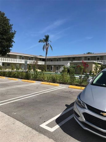 Outdoor parking area in front of a multi-story building.