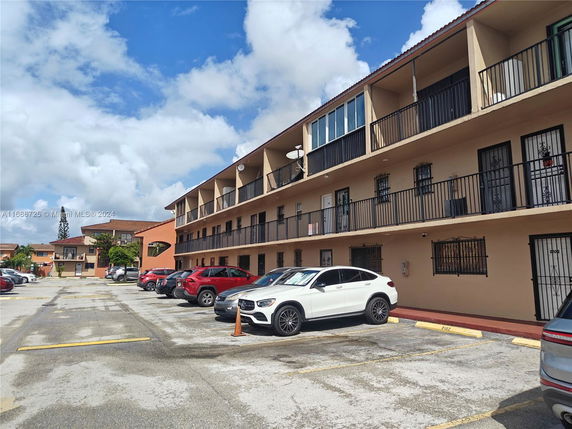 Front view of a three-story apartment building with balconies.