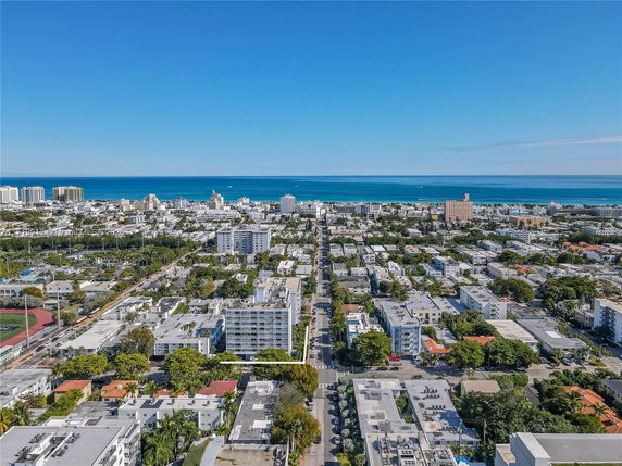 Panoramic view of a coastal city with a mix of buildings and the ocean in the background.