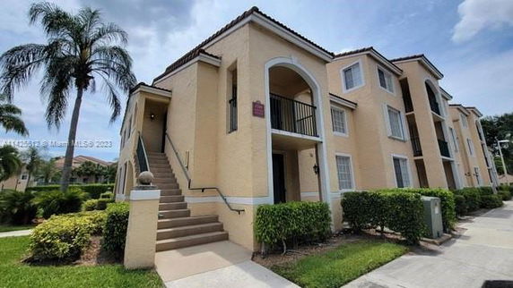 Front view of a two-story apartment building with exterior stairs.