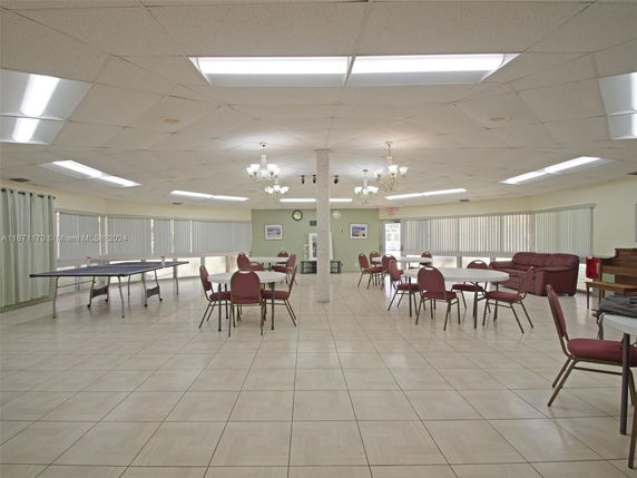 Interior view of a recreational area with tables and chairs, ping pong table, and seating.