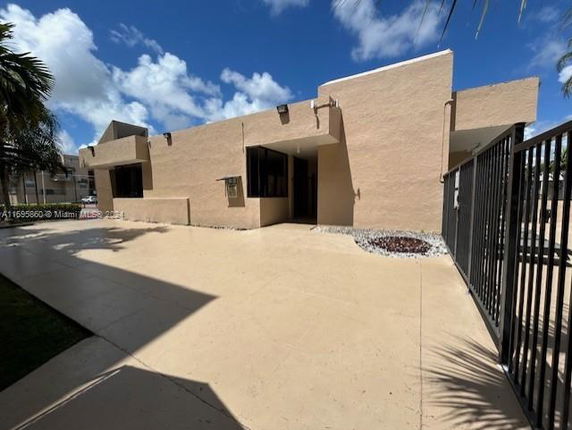 Front view of a single-story modern building with flat roof and large windows.