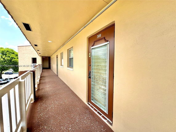 Exterior corridor view of a residential building with door number 308.