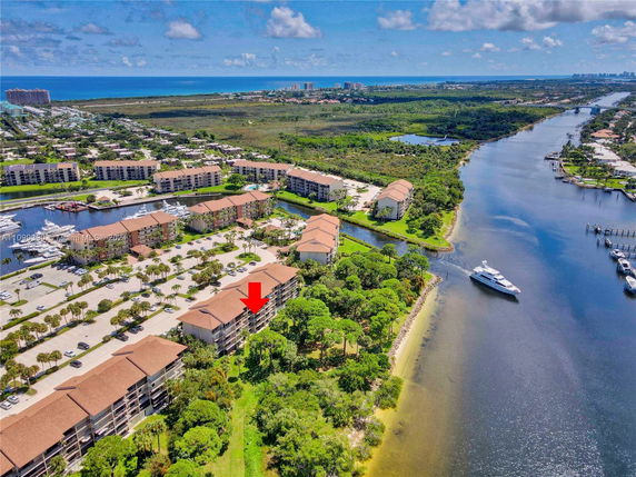 Aerial view of a waterfront residential complex with several buildings and a marina.