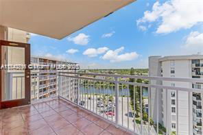 Balcony view from a high-rise building overlooking surrounding buildings and landscape.