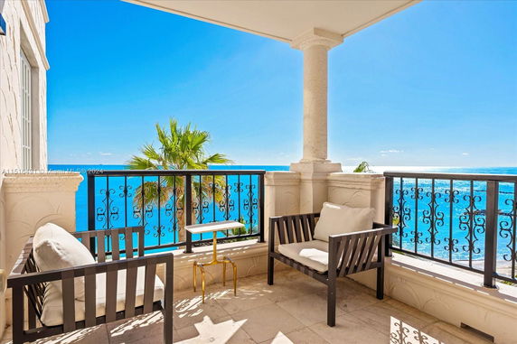 Balcony view with outdoor seating overlooking the ocean.