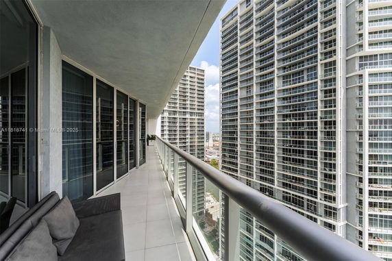 Balcony view from a high-rise building overlooking other tall buildings.