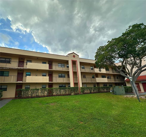 Front view of a three-story apartment building with balconies.