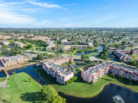 Aerial panoramic view of a suburban area with residential buildings and landscaped surroundings.