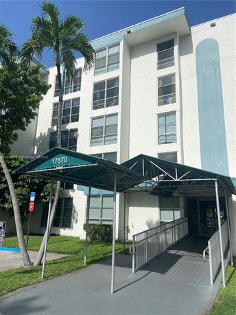 Front view of a multi-story residential building with a covered entrance.