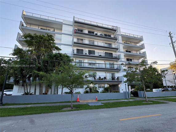Front view of a multi-story apartment building with balconies.