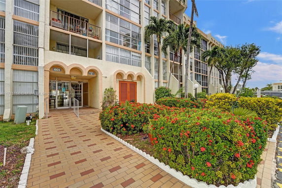 Front view of a multi-story building with a landscaped entrance.