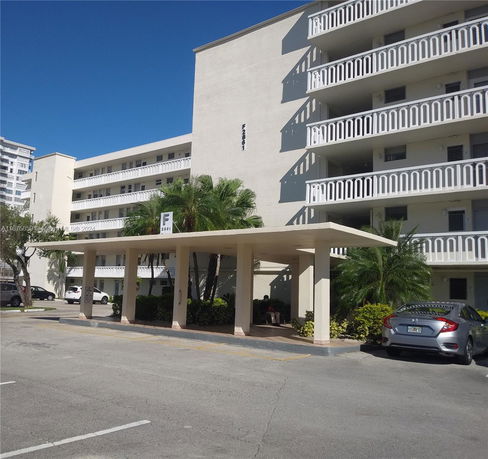 Front view of a multi-story building with balconies and covered entrance.