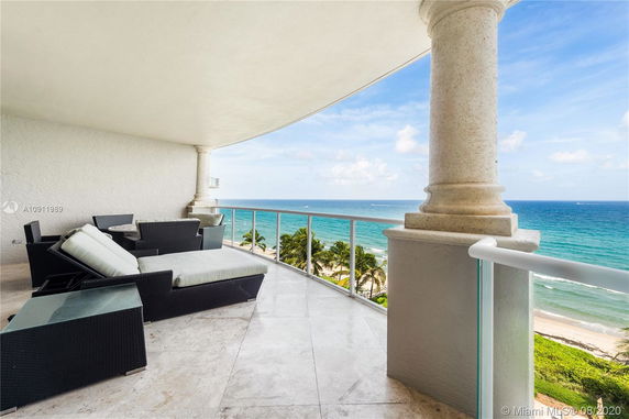 Balcony with outdoor seating overlooking the ocean.