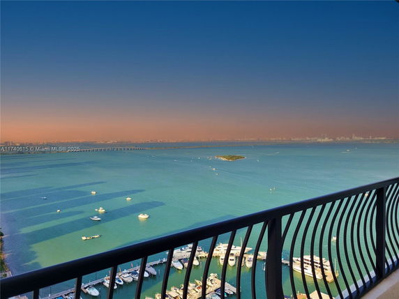 Panoramic view of the ocean and skyline from a high vantage point with boats visible below.