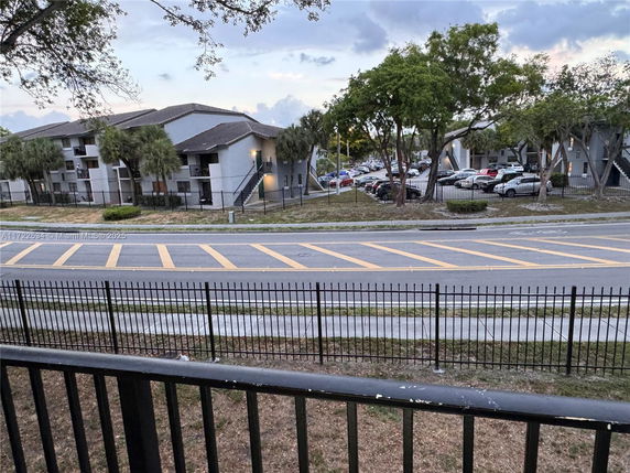 View of residential buildings and parking area from across the street.