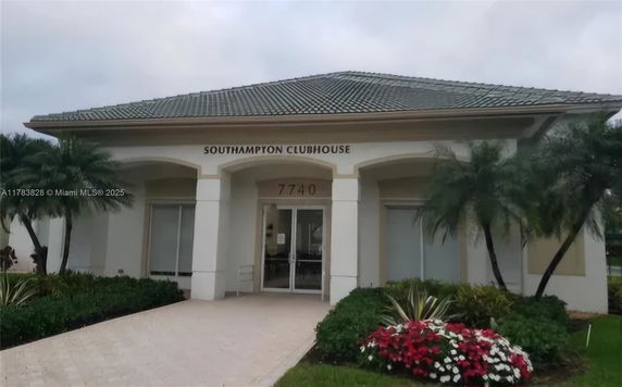 Front view of a clubhouse with a tiled roof and entrance pathway.