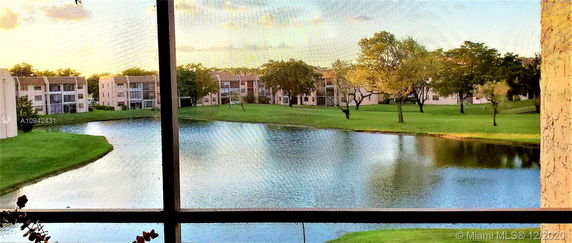 View from a building overlooking a pond, grassy area, and surrounding residential buildings.