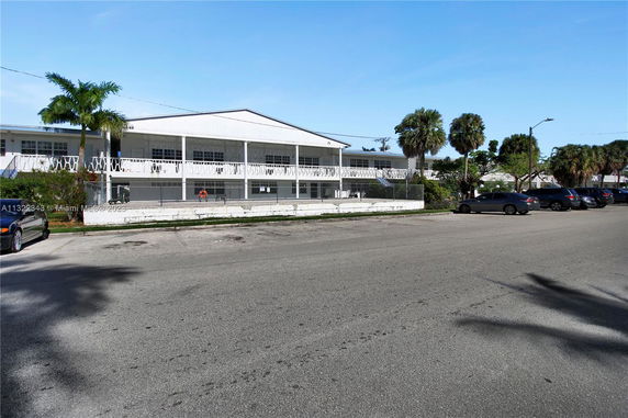 Front view of a two-story building with parking spaces in front.