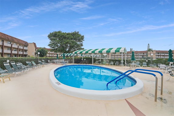 Outdoor swimming pool area with loungers and umbrellas