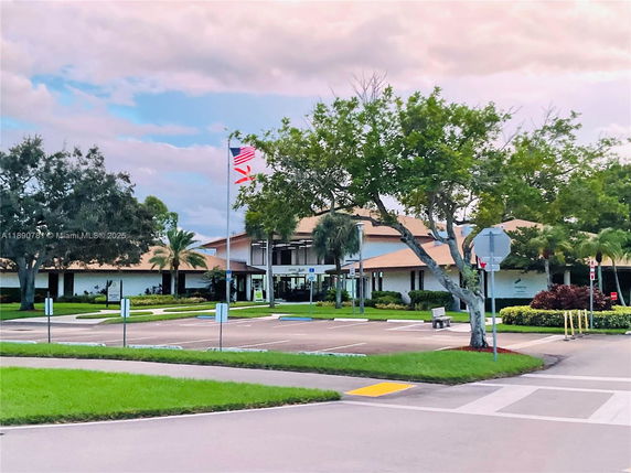 Front view of a single-story building with a parking area in front.