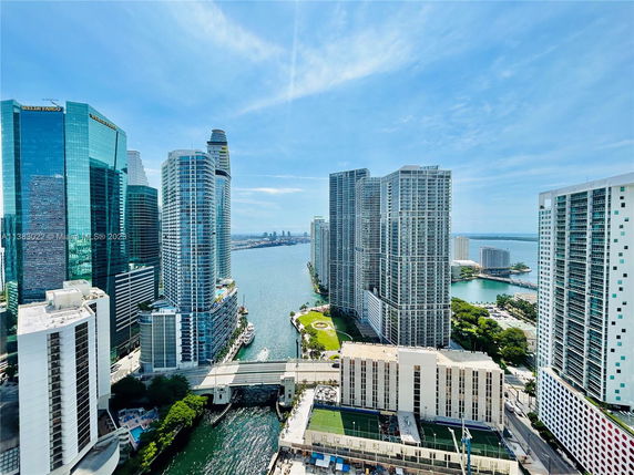 Panoramic view of tall buildings and waterways in an urban environment.