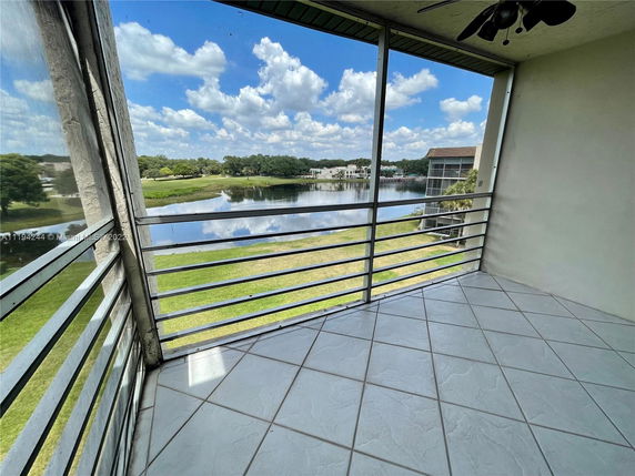 Panoramic view from a balcony overlooking a lake and surrounding greenery.