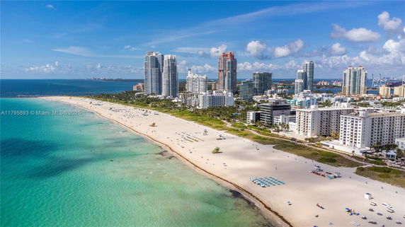 Panoramic view of beachfront skyline with high-rise buildings and sandy beach.