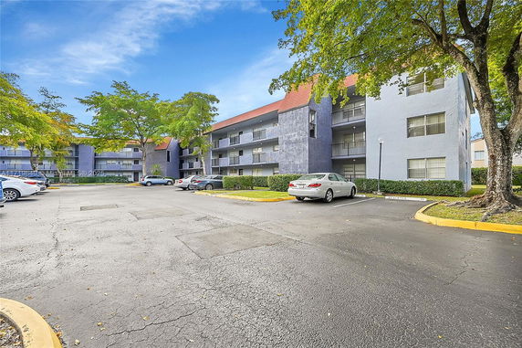 Outdoor parking area in front of a multi-story residential building.