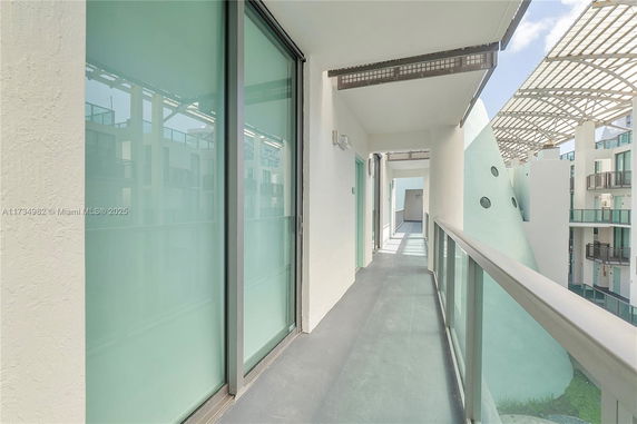 View from a corridor with glass railings overlooking a modern building.