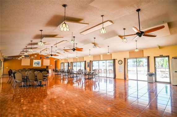 Large indoor area with multiple tables and chairs arranged for a gathering.