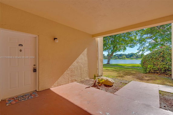 View of a pathway leading to a grassy area and a lake.
