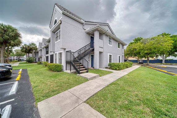 Front view of a two-story residential building with external staircases.