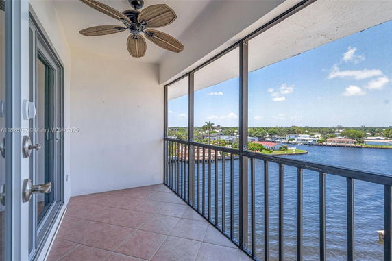 Balcony view overlooking a waterway with distant houses and trees.