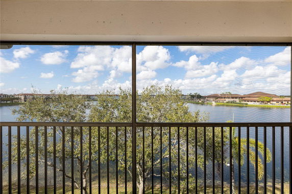 Outdoor view of a lake and trees from a balcony.