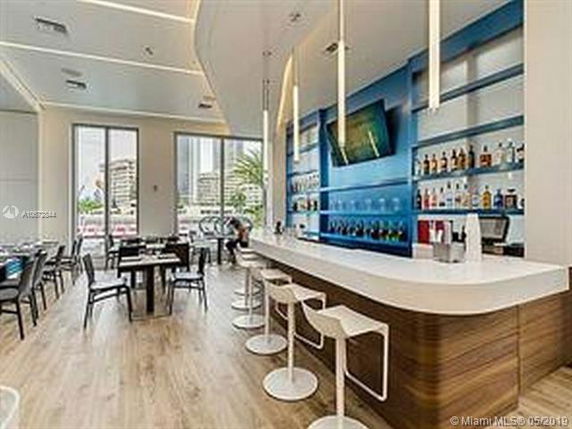Interior view of a modern bar with counter seating and a blue accent wall.