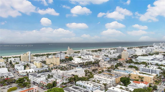 Wide-angle view of a coastal cityscape with multiple buildings and the ocean in the background.