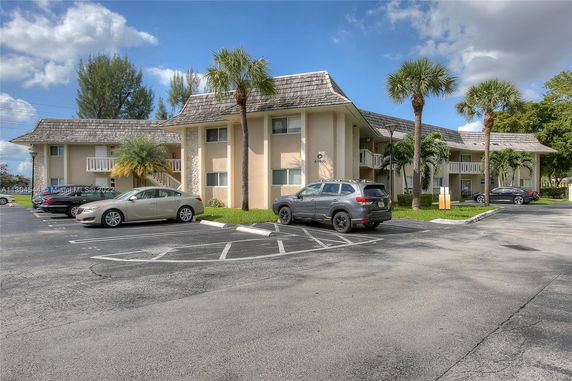 Outdoor parking area in front of a two-story building.