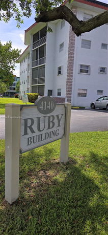 Partial front view of a multi-story residential building with a sign reading 'Ruby Building'.