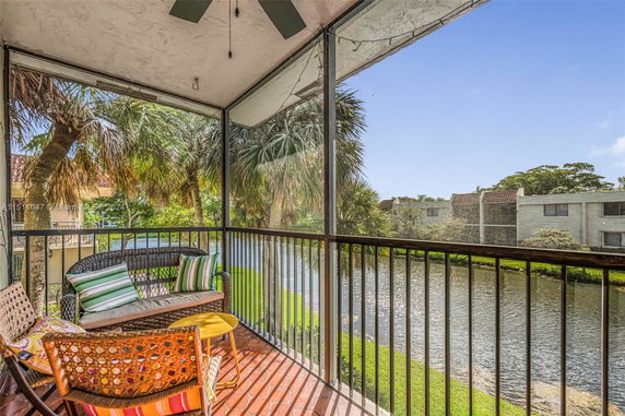 Screened balcony overlooking a waterway and nearby buildings.