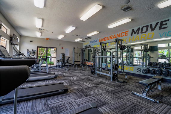 Indoor gym with exercise equipment and motivational wall graphics.