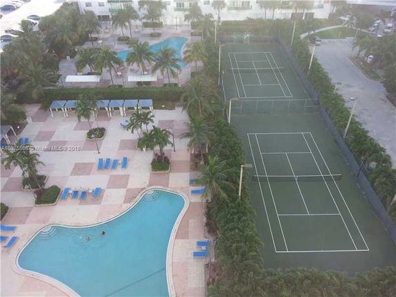 Aerial view of swimming pools and tennis courts in an outdoor recreational area.