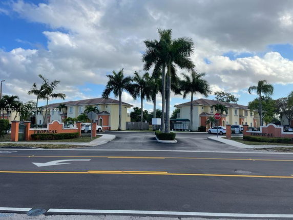 Front view of a residential complex with multiple two-story buildings and a gated entrance.