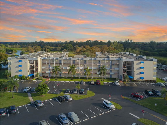 Front view of a multi-story apartment building with parking area.
