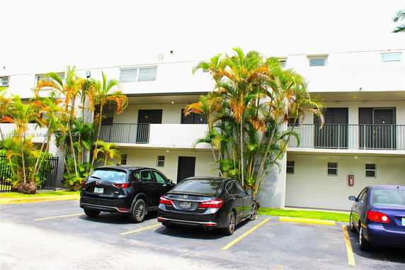 Outdoor parking area in front of a multi-story building.