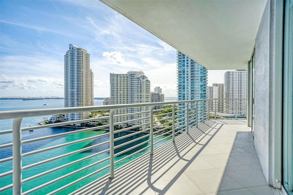 Panoramic view from a balcony overlooking high-rise buildings and a waterfront.
