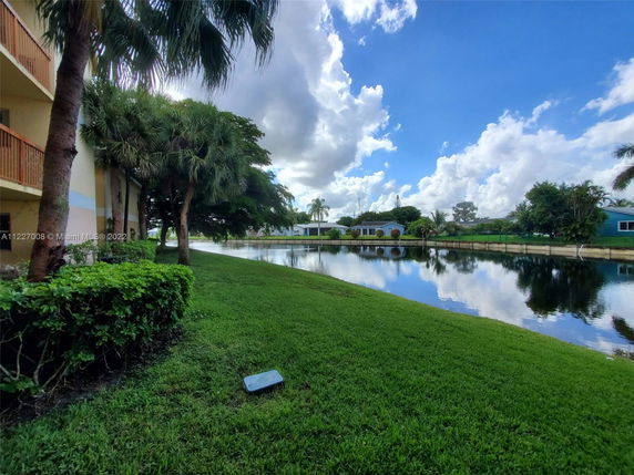 View of a lake and surrounding landscape with trees and buildings.