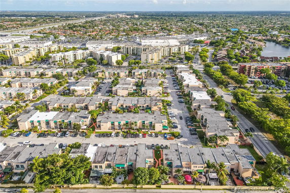 Panoramic aerial view of a residential neighborhood with multiple row houses and parking areas.